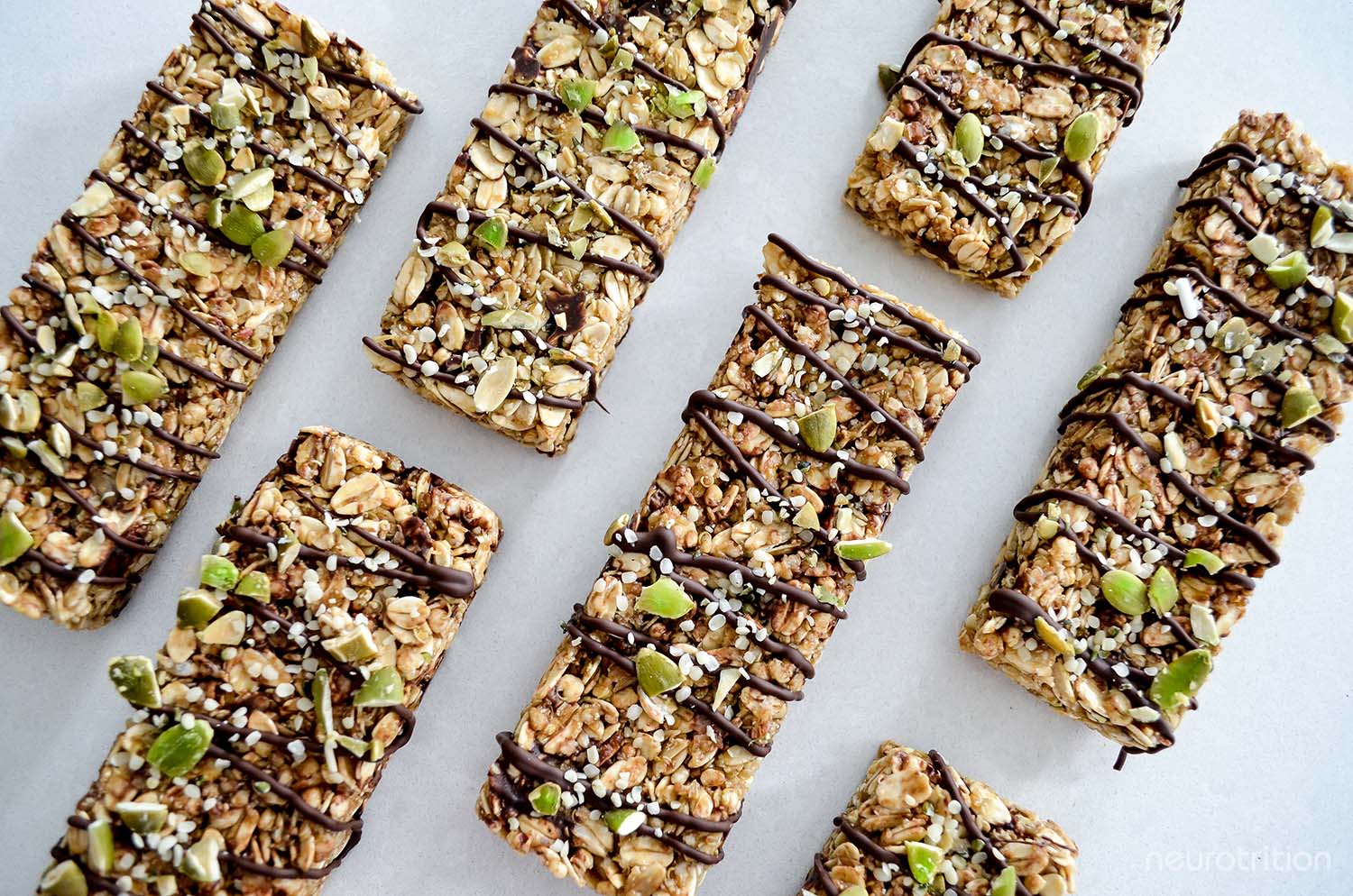 Granola Bars Flatlay of several granola bars in a grid formation, with chocolate drizzled across all the bars.