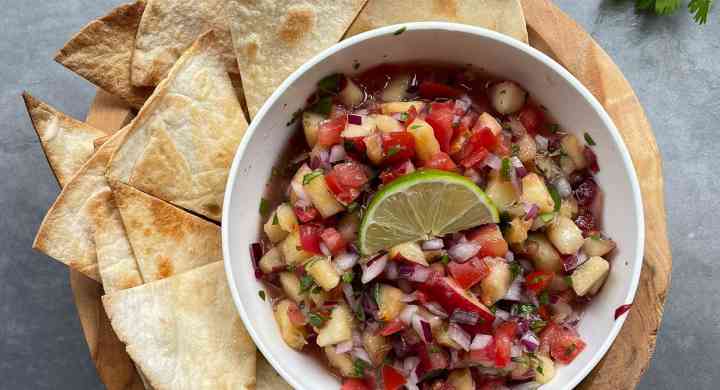 Fresh Stone Fruit Salsa A bowl of homemade salsa is surrounded by baked pita chips on a wooden tray.