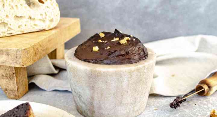 Simple Neuro-Nutella A stone dish full of homemade chocolate spread is surrounded by slices of bread that are covered in the chocolate spread and topped with crushed walnuts.