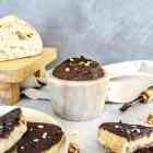 A stone dish full of homemade chocolate spread is surrounded by slices of bread that are covered in the chocolate spread and topped with crushed walnuts.